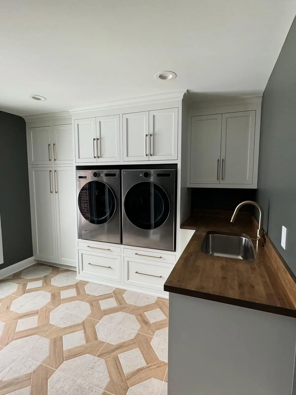 Laundry room after — stacked cabinetry and patterned tile