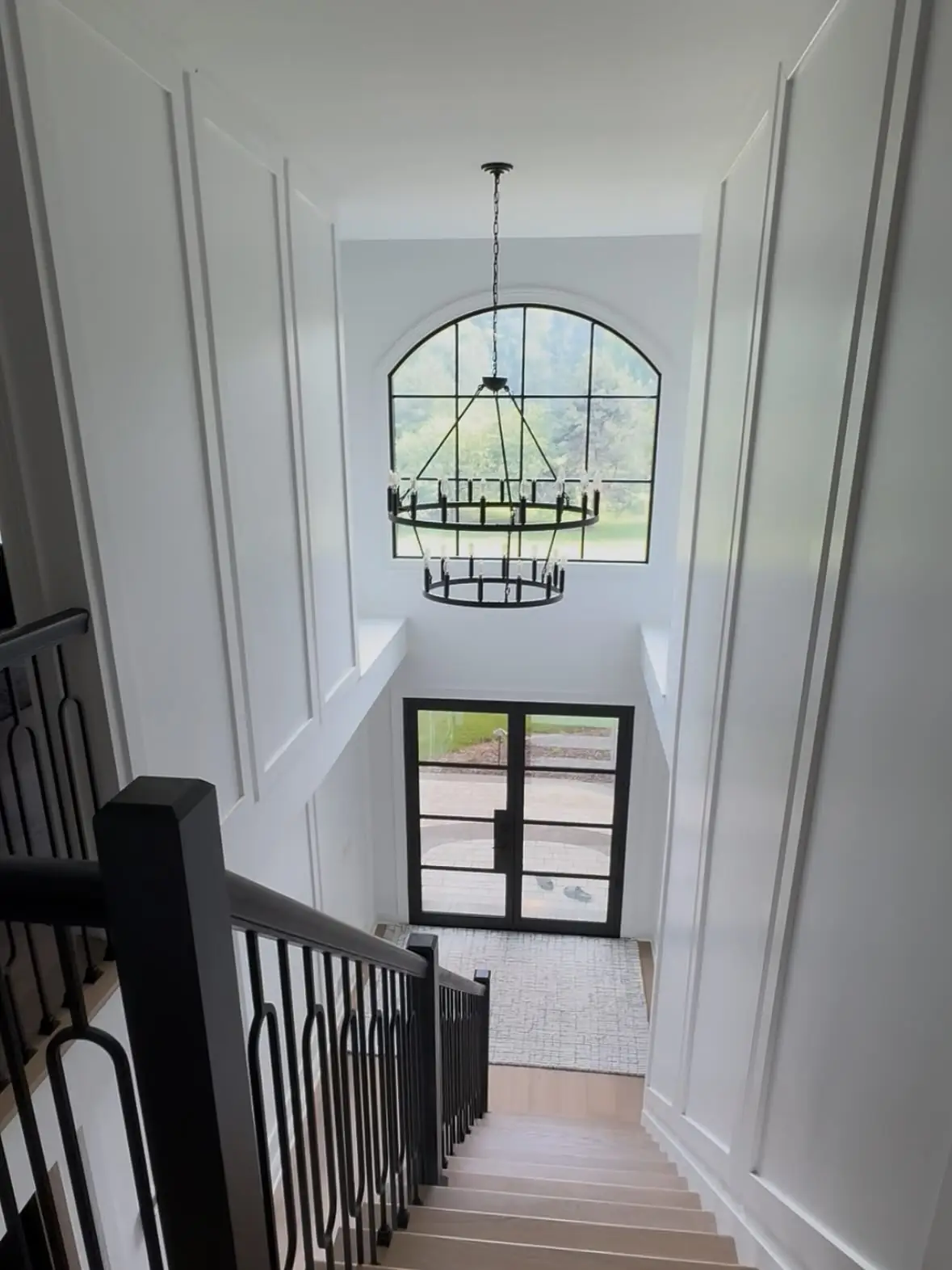 Two-story foyer with arched window and chandelier
