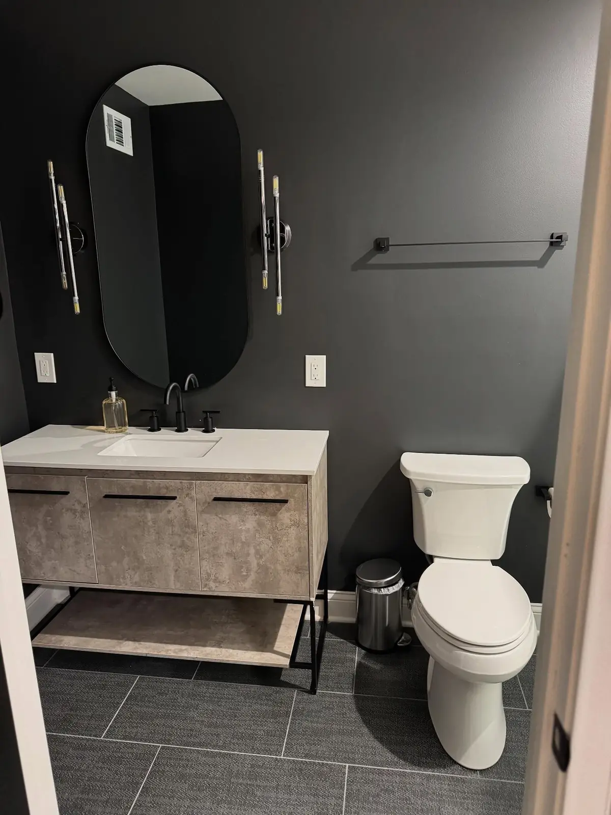 Powder room after — floating vanity and oval mirror
