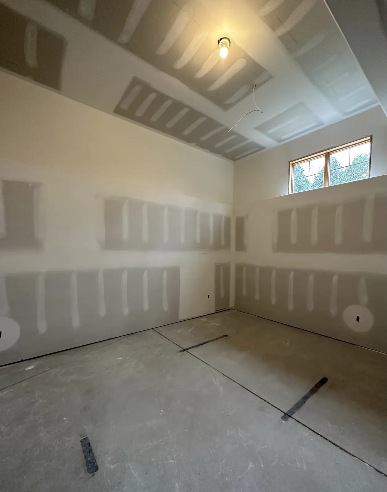 Sports den before — bare drywall