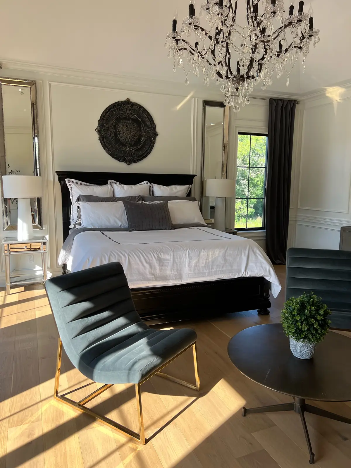 The bed beneath a carved medallion, flanked by mirrored panels