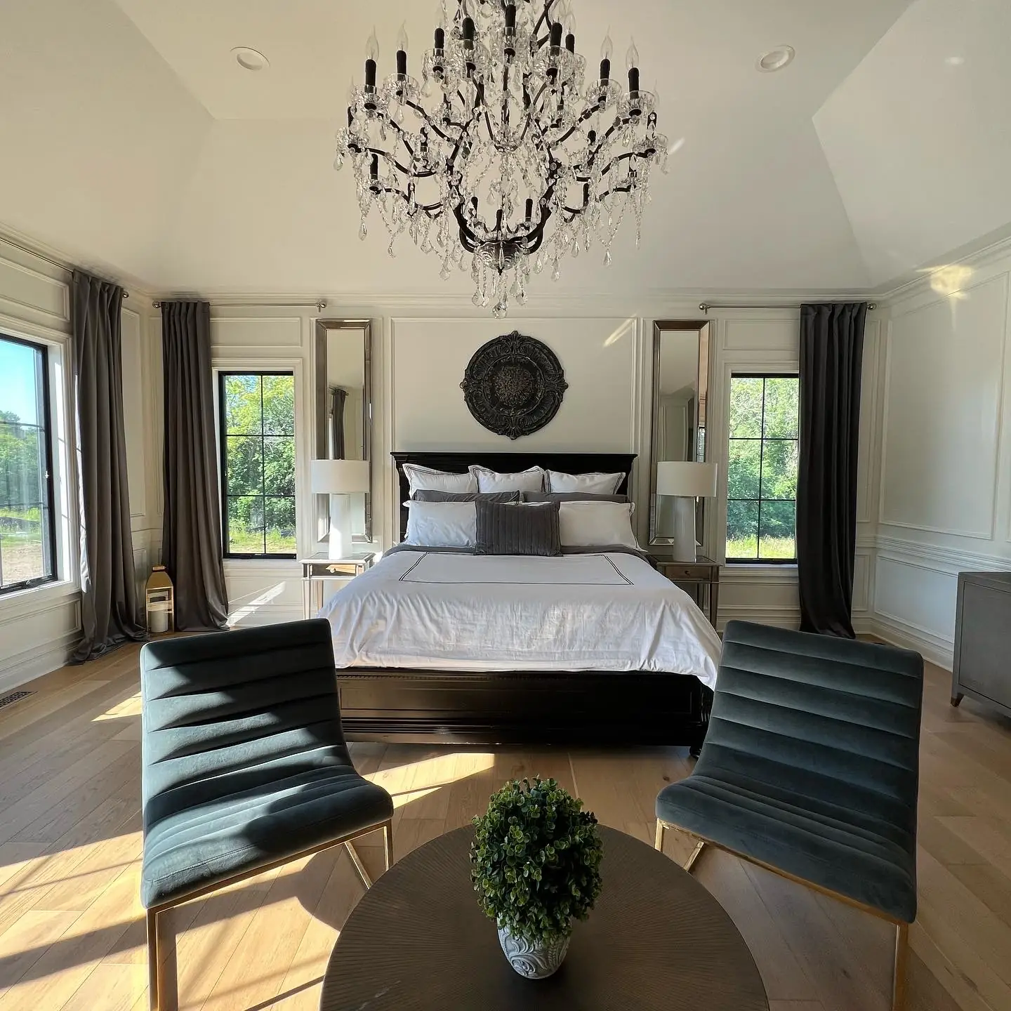 Primary bedroom beneath a crystal chandelier — French-Inspired Residence