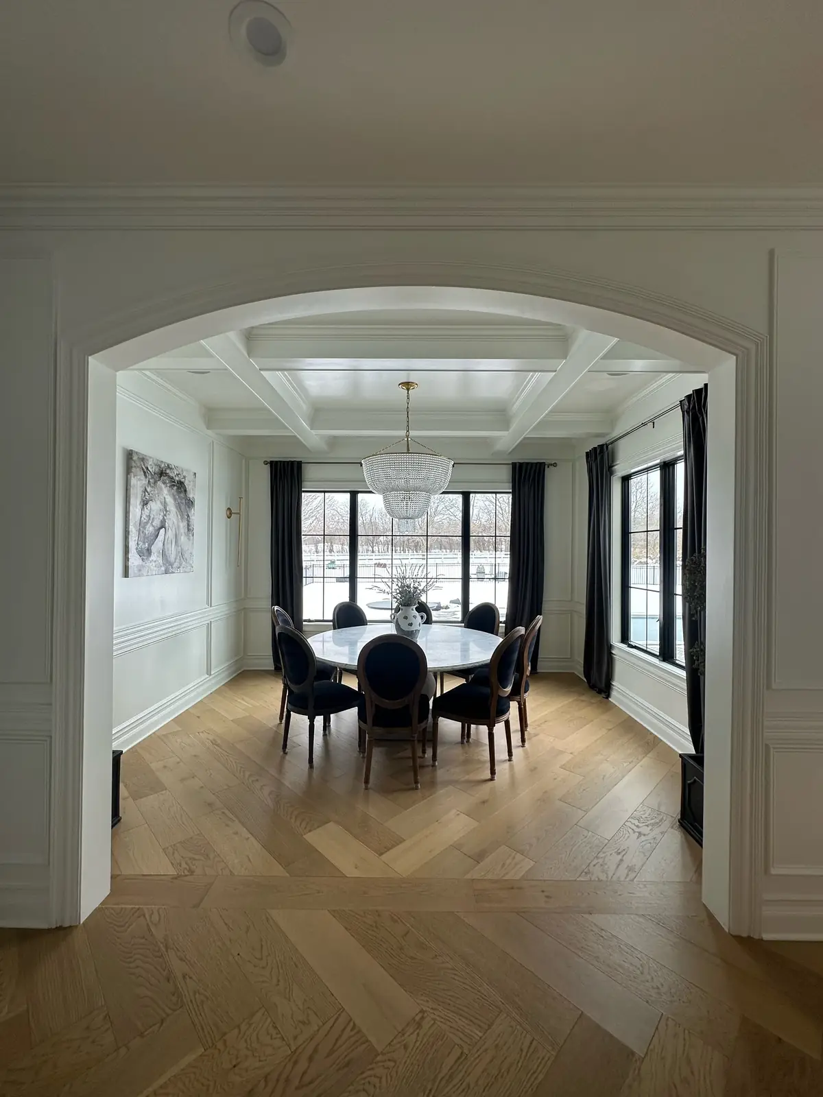 Dining room through an arched opening — French-Inspired Residence
