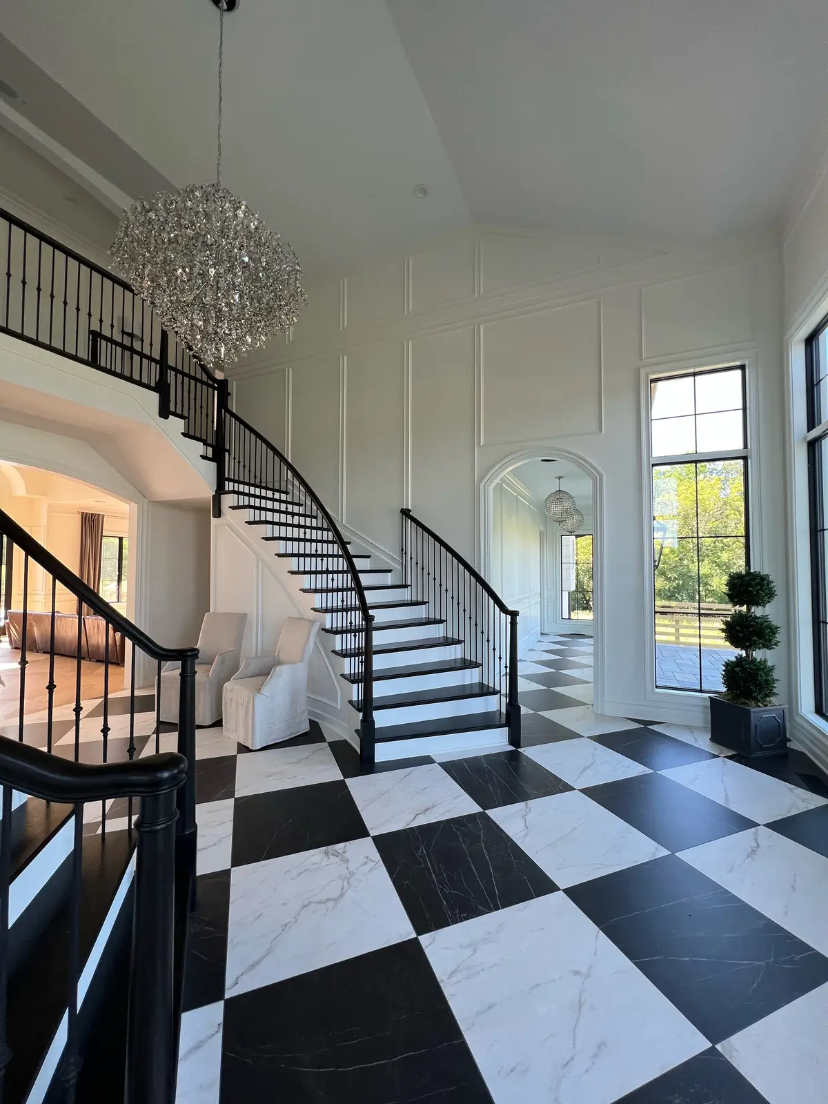 The double staircase and balcony over checkerboard marble — French-Inspired Residence