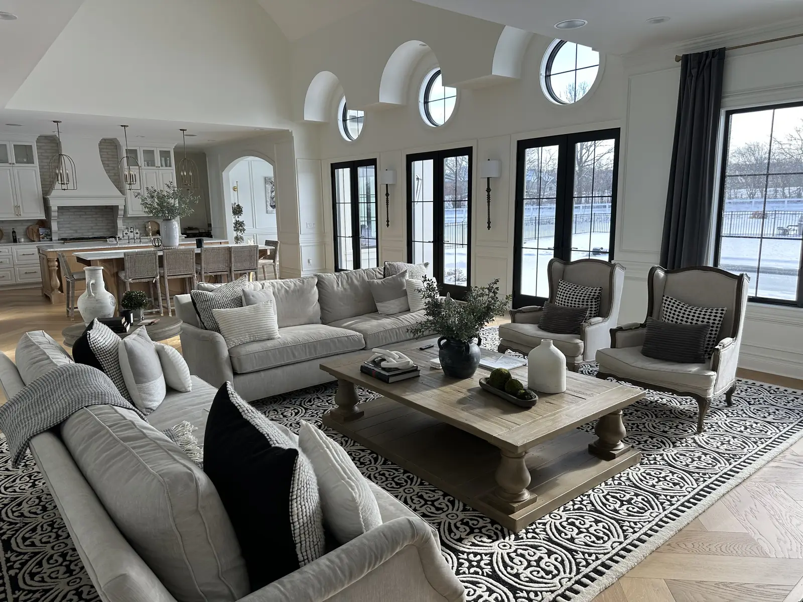 Great room with arched dormers and oculus windows — French-Inspired Residence