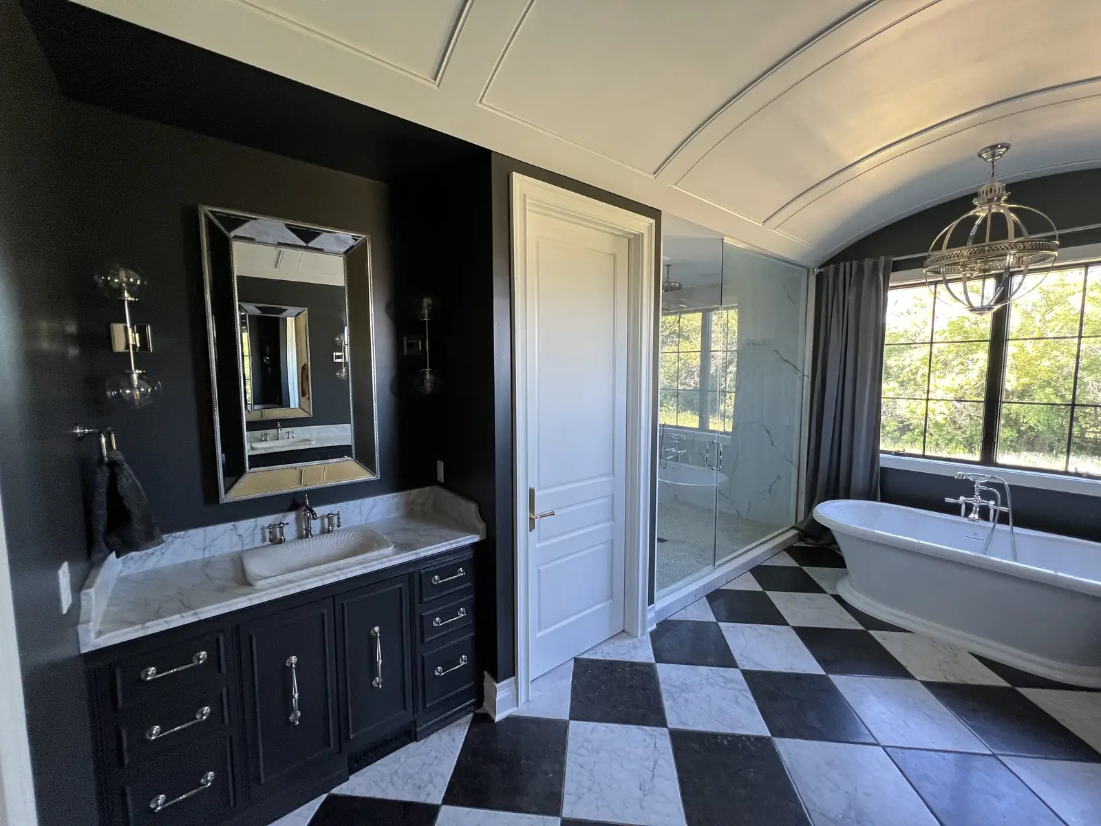 Barrel-vaulted primary bath with freestanding tub — French-Inspired Residence