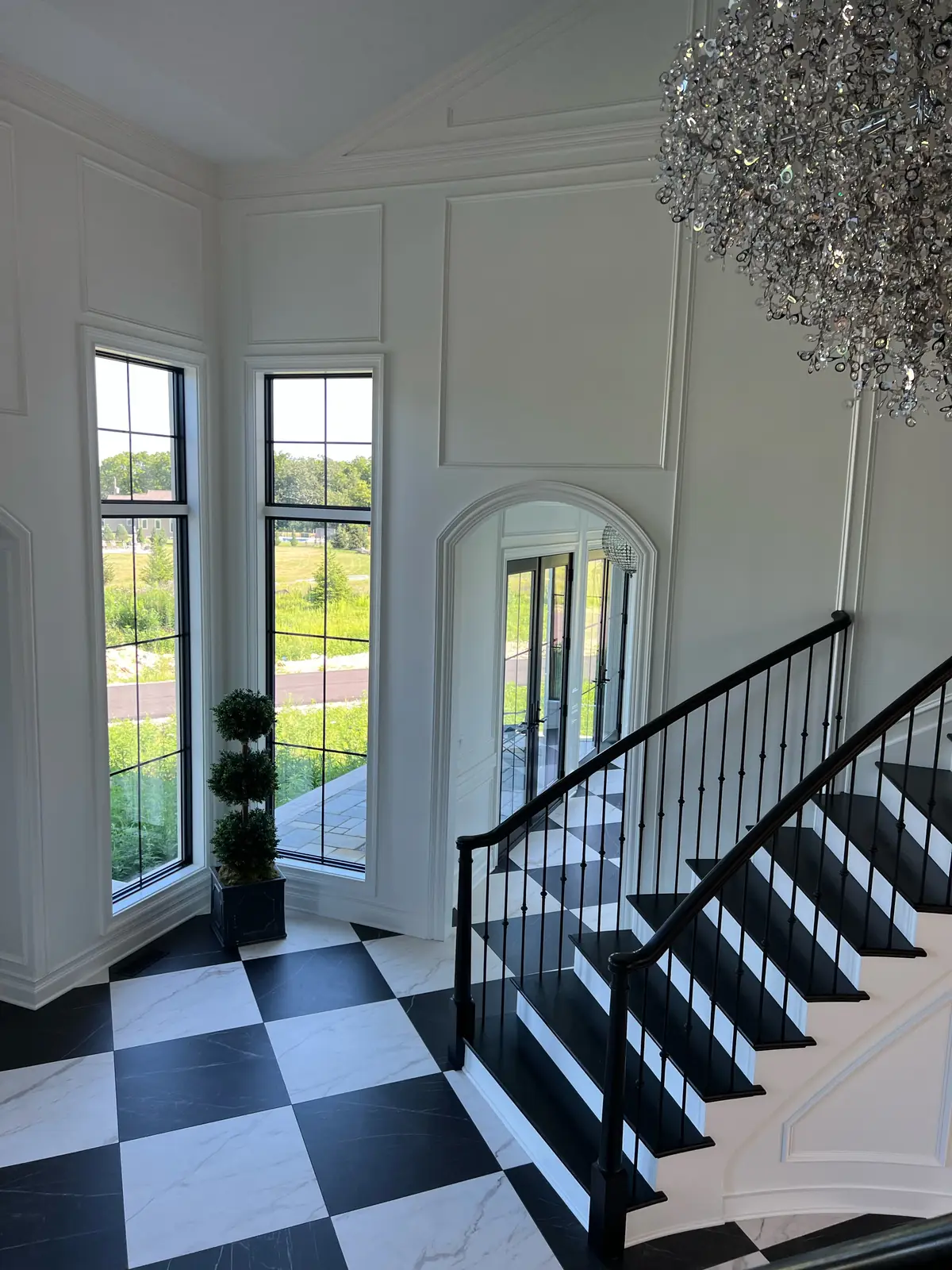 The stair from above, with two tall windows and the arched hall