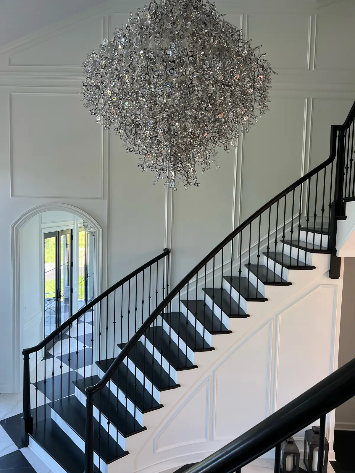 The curved staircase beneath the large crystal chandelier