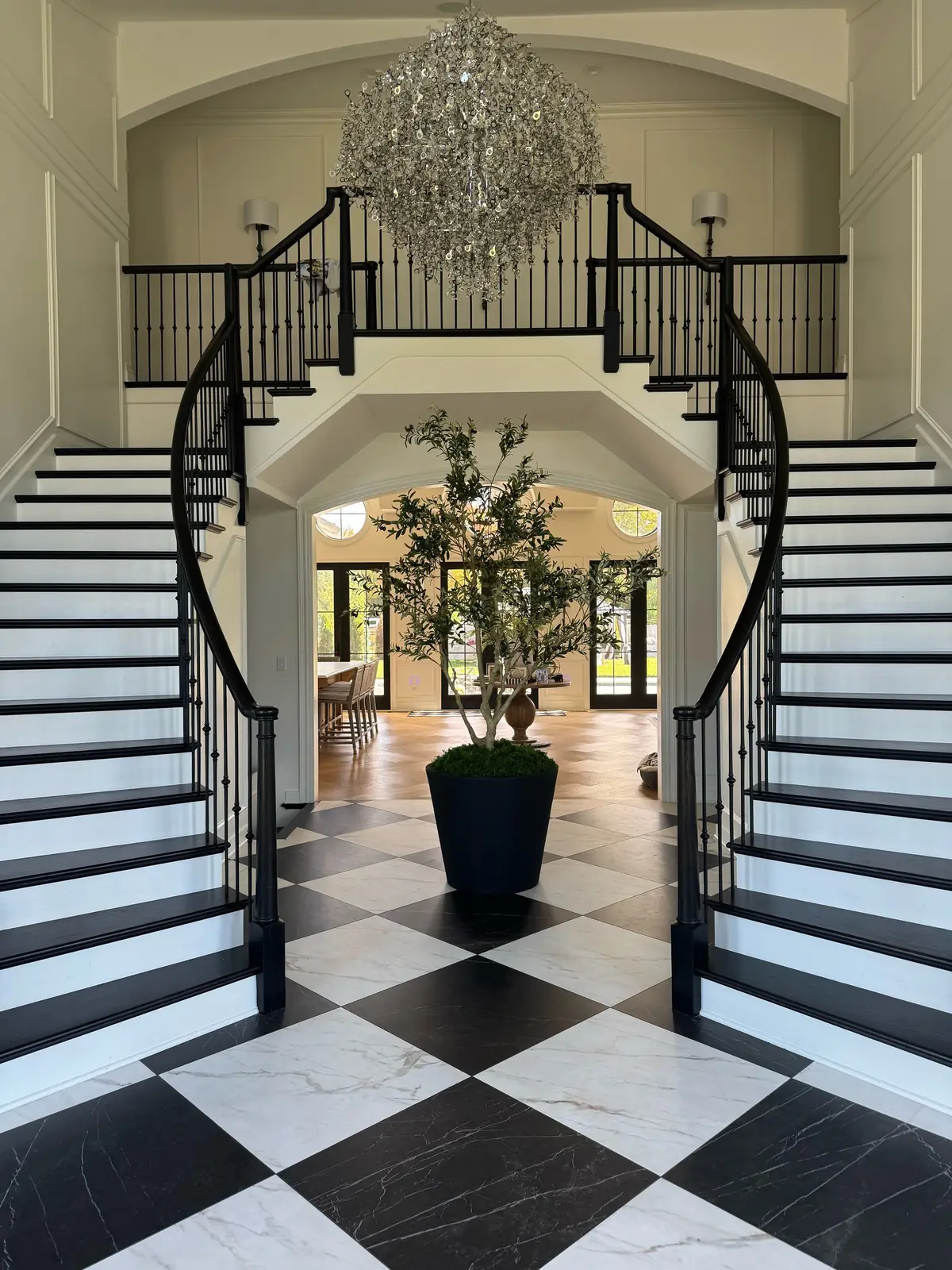 An olive tree beneath the chandelier — French-Inspired Residence