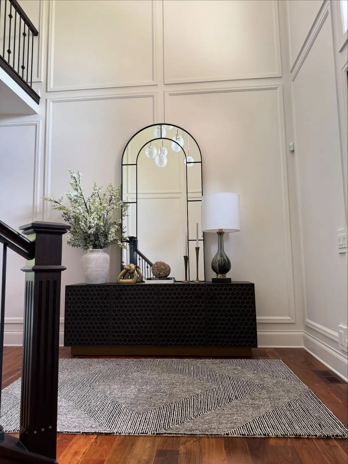 Foyer console beneath an arched mirror