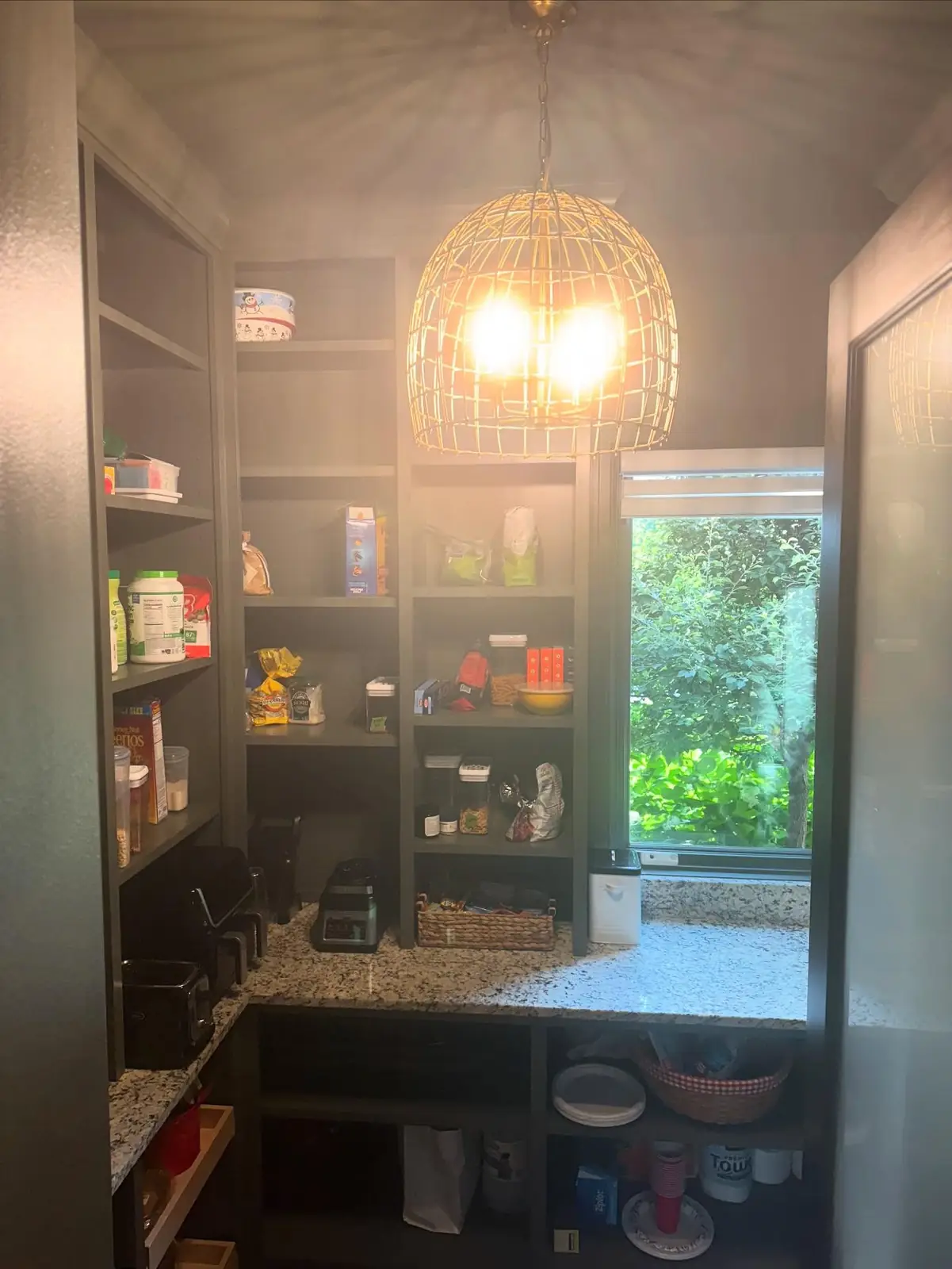 Pantry with a woven pendant and dark shelving