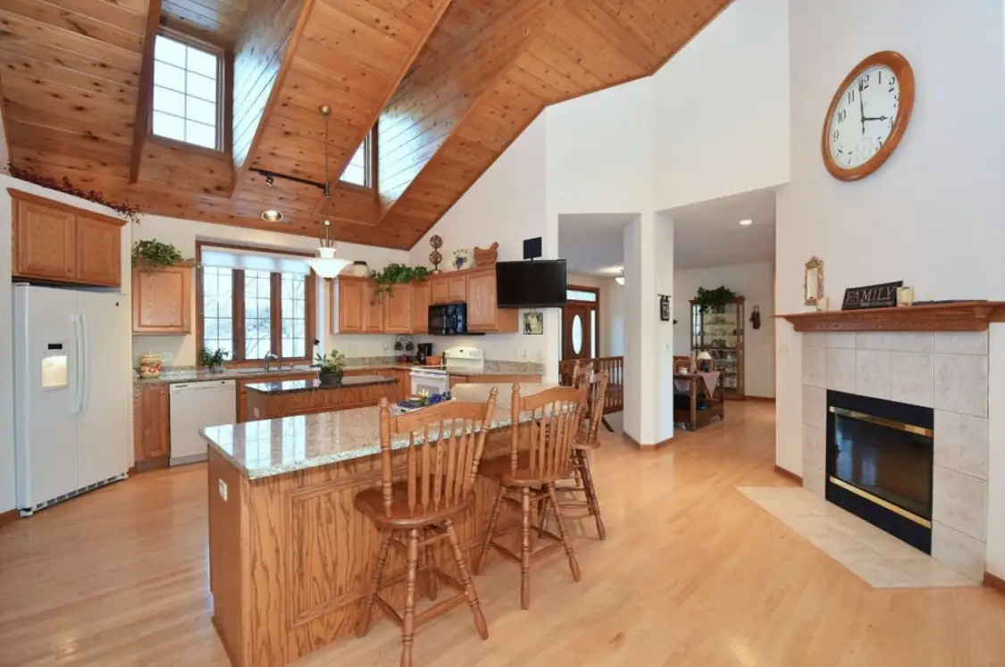 Kitchen before — oak cabinets and island beneath the cedar ceiling